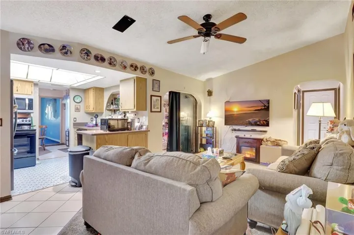 Tiled living room featuring a textured ceiling and ceiling fan