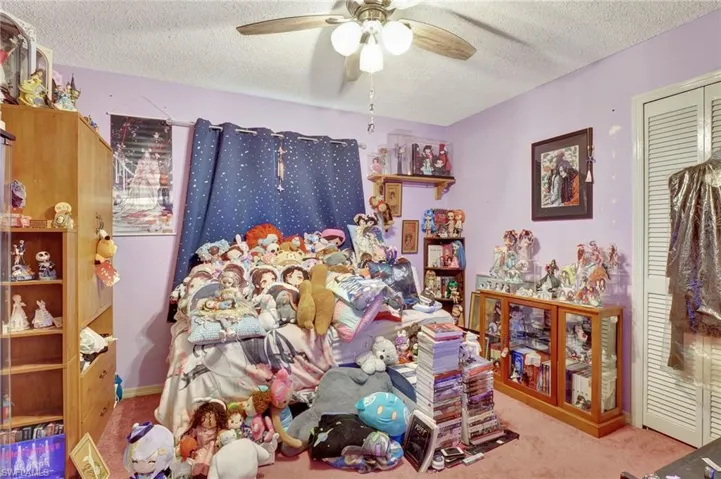 Carpeted bedroom featuring a closet, ceiling fan, and a textured ceiling
