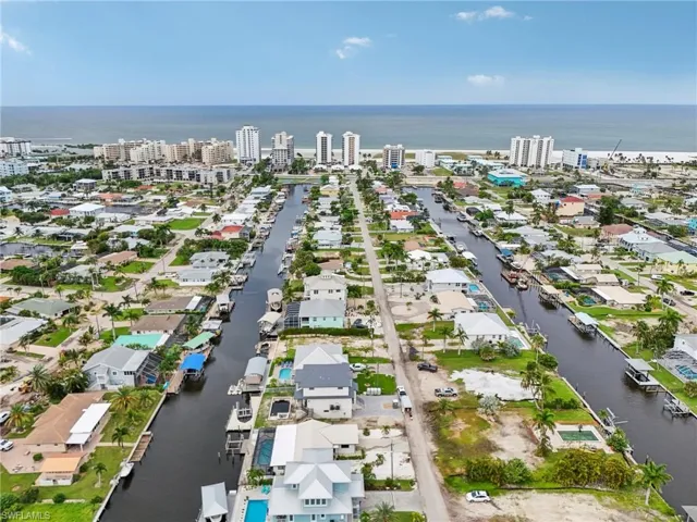 Aerial view of property and surrounding area with a nearby body of water and nearby suburban area