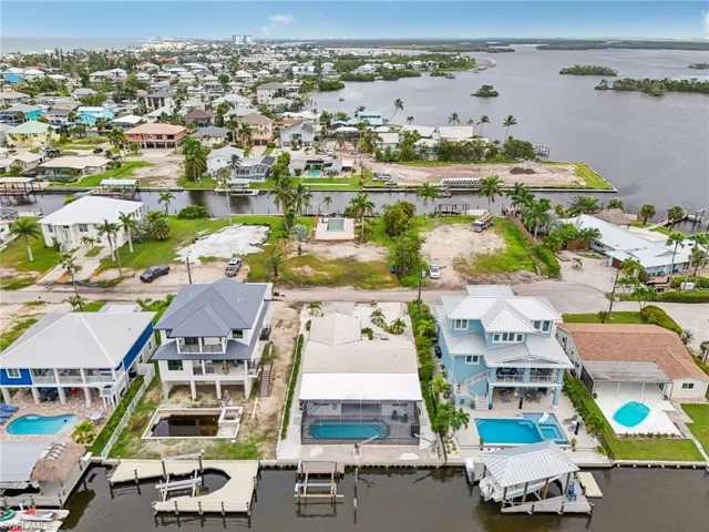 Aerial view of residential area with a nearby body of water and a pool area