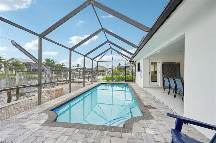 Outdoor pool with a patio area, a sunroom, a lanai, and a water view