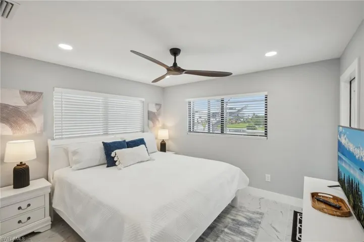 Bedroom featuring light marble finish floors, recessed lighting, and a ceiling fan