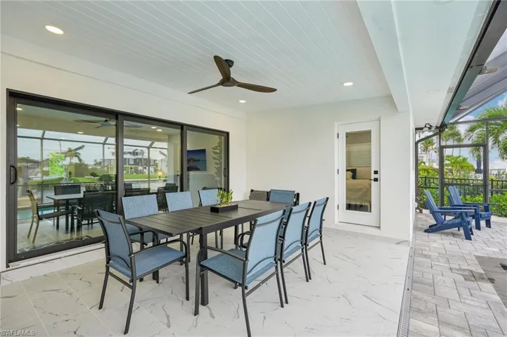 View of patio / terrace featuring outdoor dining space, a sunroom, a ceiling fan, and a lanai