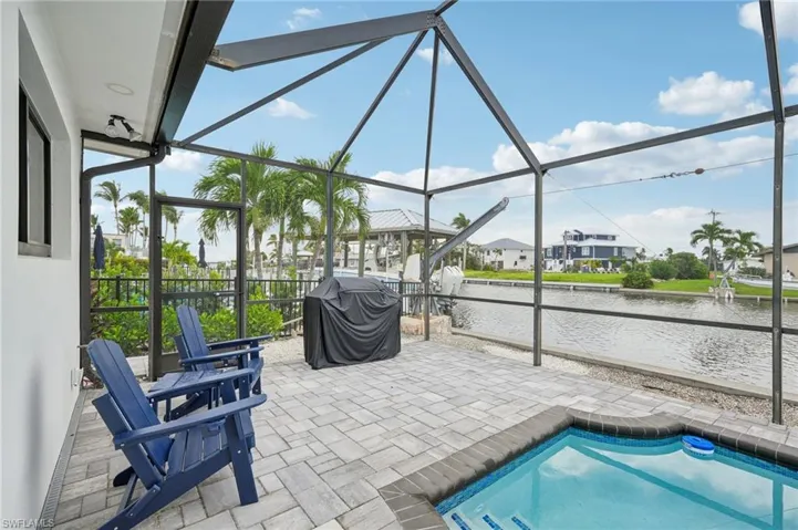 Outdoor pool with a patio area, a lanai, a sunroom, and a grill