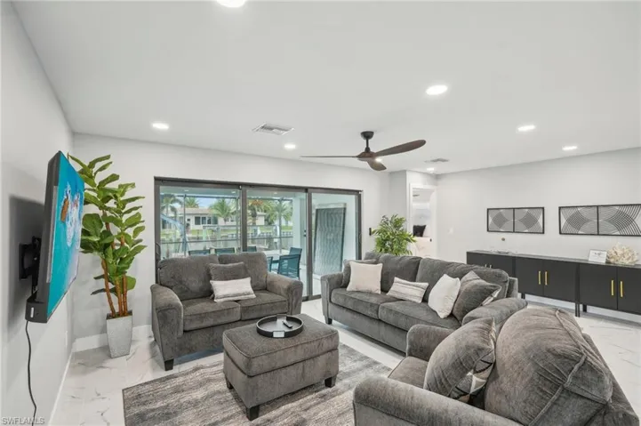 Living room with light marble finish floors, recessed lighting, and ceiling fan