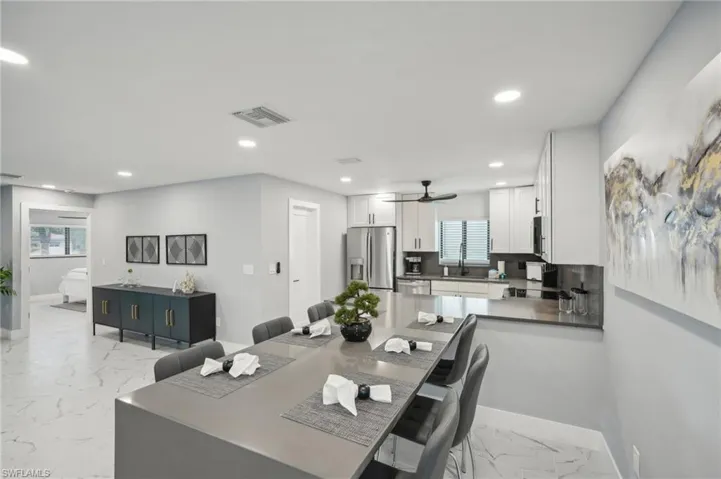 Dining space featuring recessed lighting and light marble finish flooring