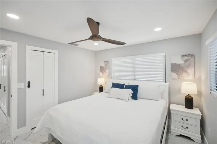 Bedroom featuring light marble finish floors, a closet, recessed lighting, and a ceiling fan