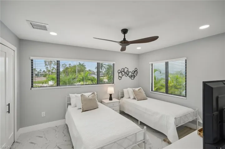 Bedroom with marble look tiles, a ceiling fan, and recessed lighting