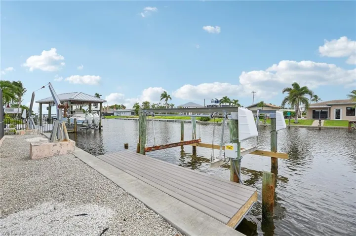 Dock area featuring boat lift and a water view