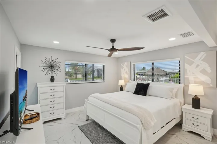 Bedroom with light marble finish floors, multiple windows, a ceiling fan, and recessed lighting