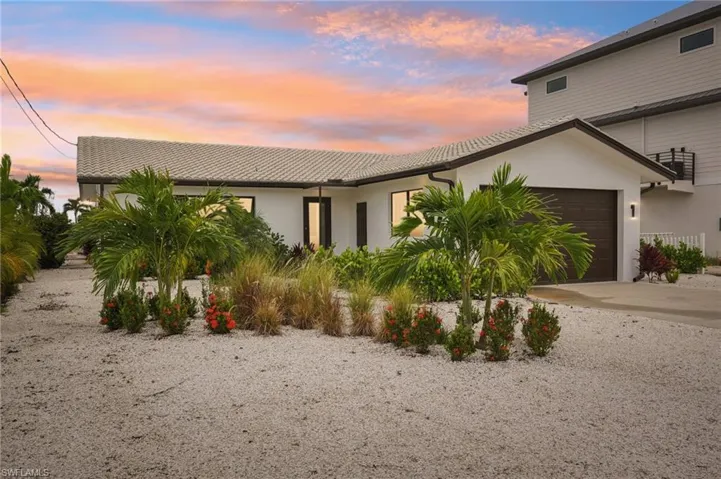 View of front of house featuring stucco siding, concrete driveway, and an attached garage
