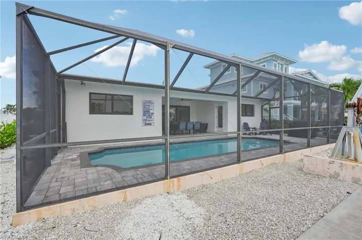 Swimming pool with a sunroom, a patio, a lanai, and a ceiling fan