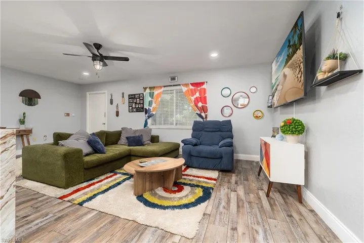 Living room with ceiling fan and hardwood / wood-style floors