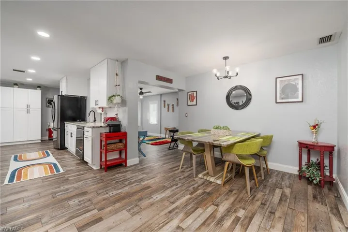 Dining space featuring sink, a notable chandelier, and wood-type flooring