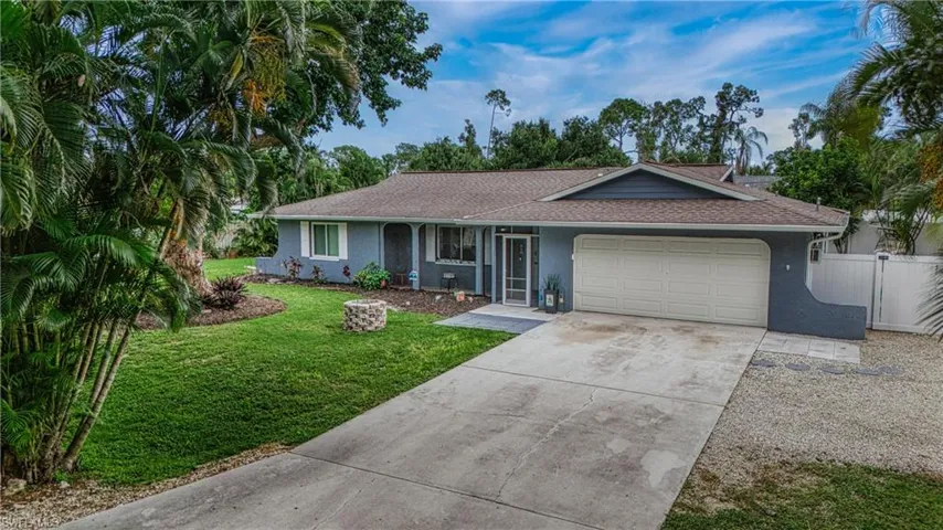 Ranch-style home featuring a front lawn and a garage