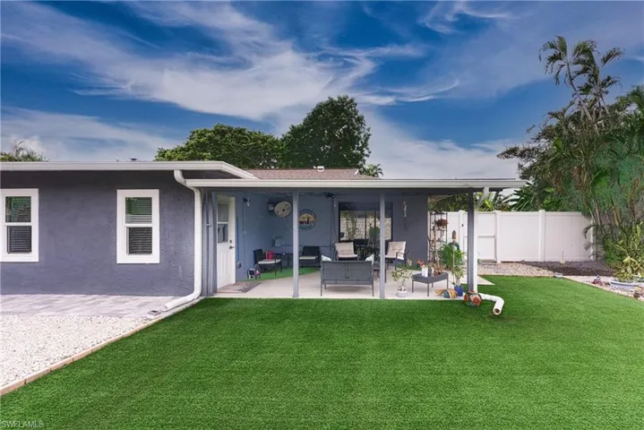 Rear view of property with a patio area, a yard, and an outdoor living space
