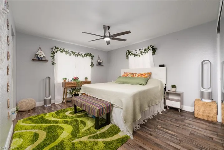 Bedroom with ceiling fan and dark wood-type flooring