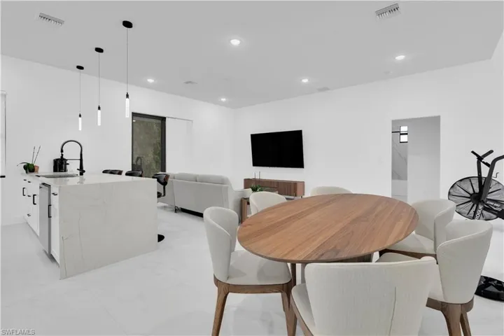 Dining space with recessed lighting and light marble finish flooring