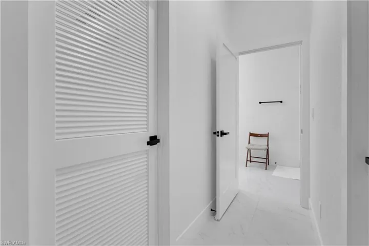 Hall with light marble finish flooring and baseboards