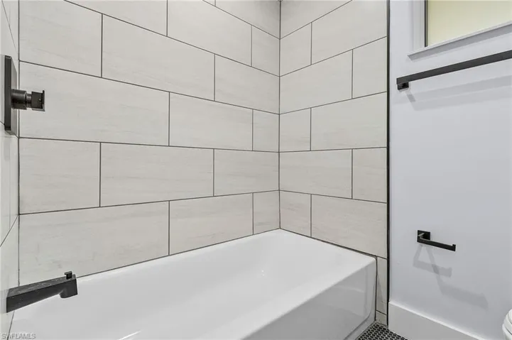 Full bathroom with a tub and toilet