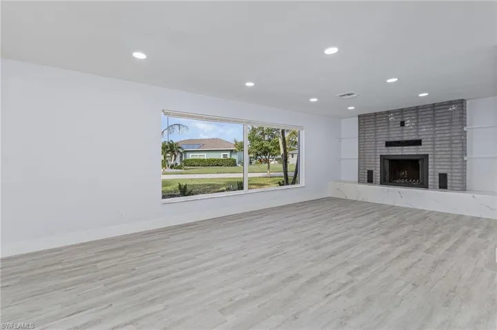 Unfurnished living room with recessed lighting, wood finished floors, and a fireplace