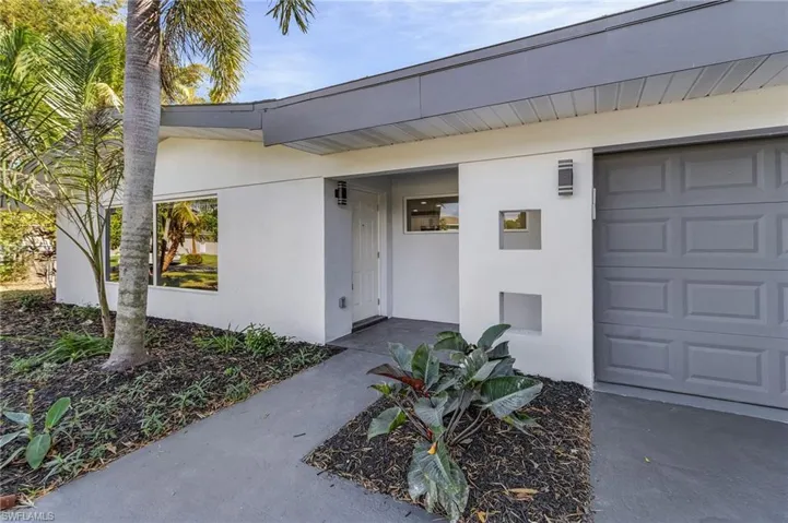 Entrance to property with stucco siding and a garage