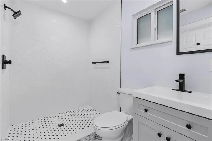 Full bathroom featuring a tile shower, vanity, and recessed lighting