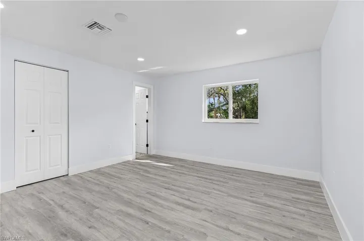 Unfurnished bedroom featuring light wood-type flooring, recessed lighting, and a closet
