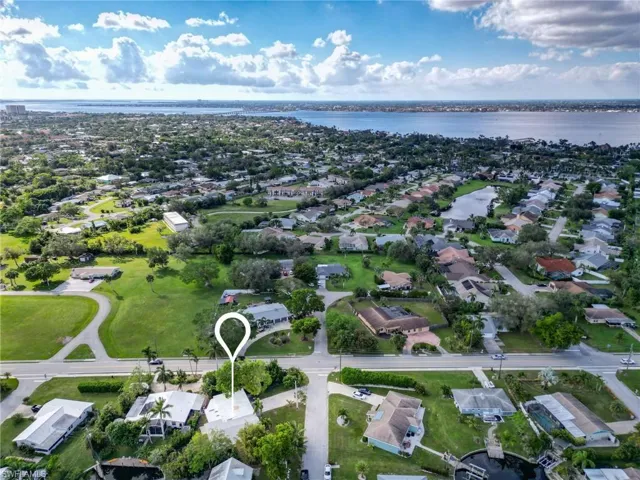 Aerial overview of property's location featuring a nearby body of water and nearby suburban area