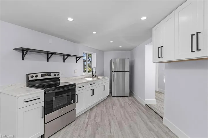 Kitchen featuring stainless steel appliances, open shelves, recessed lighting, white cabinets, and light wood-type flooring