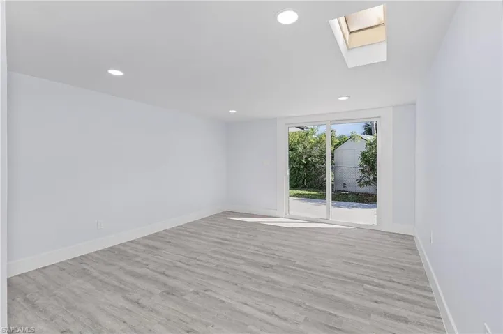 Empty room with a skylight, wood finished floors, and recessed lighting