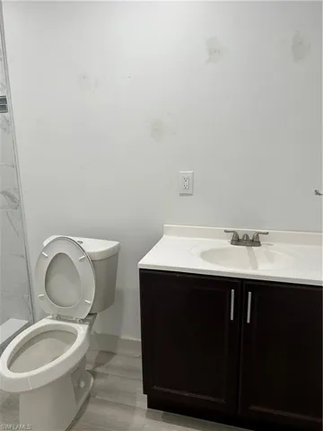 Bathroom with toilet, hardwood / wood-style flooring, and vanity