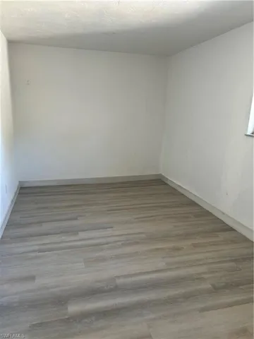 Spare room featuring a textured ceiling and hardwood / wood-style floors