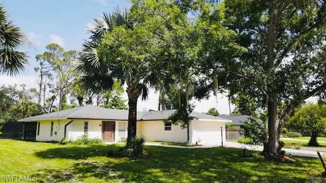 Ranch-style house featuring a garage and a front lawn