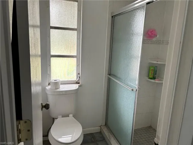 Bathroom with tile patterned flooring, toilet, and walk in shower
