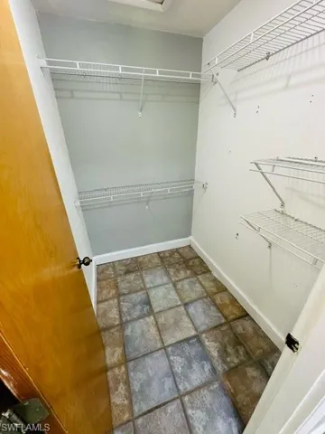 Walk in closet featuring dark tile patterned floors