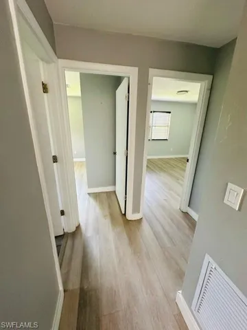 Hallway with light hardwood / wood-style flooring