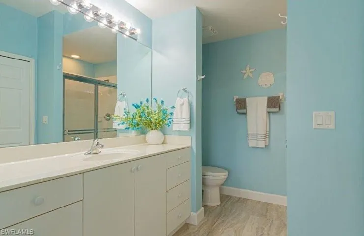 Bathroom with a shower stall, vanity, and light wood-type flooring