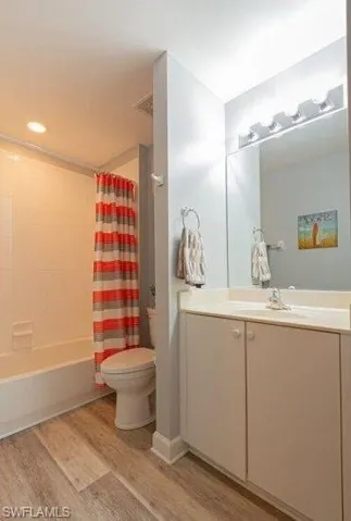 Full bathroom featuring light wood-style floors, shower / tub combo, and vanity