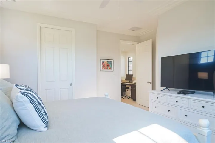 Bedroom featuring ensuite bath, ceiling fan, and ornamental molding