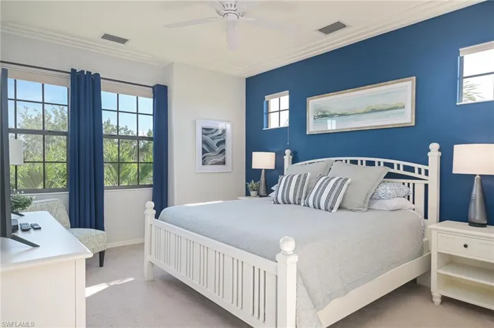 Carpeted bedroom with crown molding, multiple windows, and ceiling fan