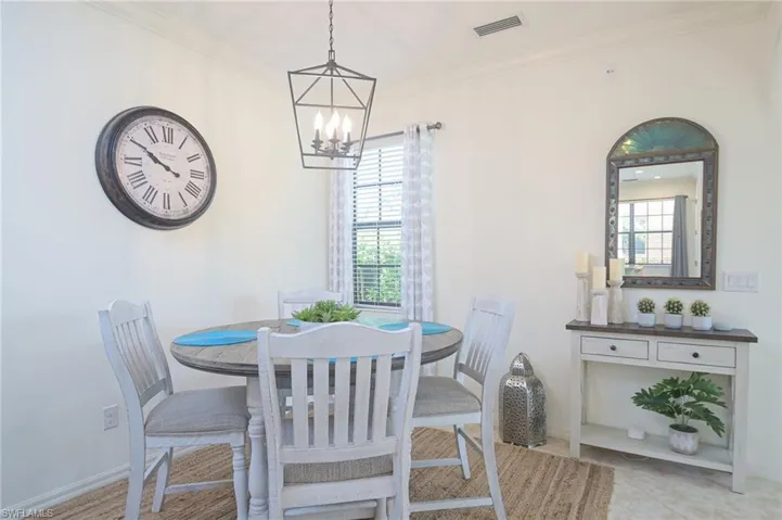 Dining area featuring ornamental molding, a notable chandelier, and light tile patterned floors