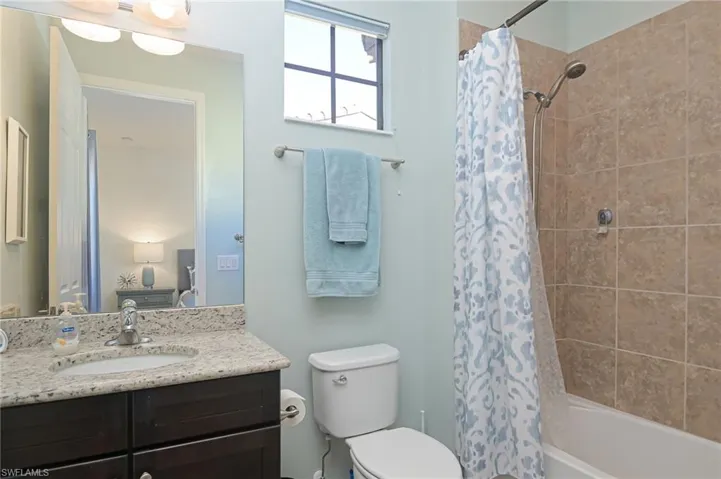 Full bathroom featuring toilet, shower / bath combination with curtain, and vanity