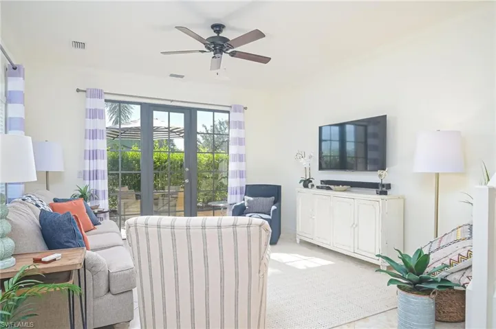 Living room with french doors, crown molding, and ceiling fan