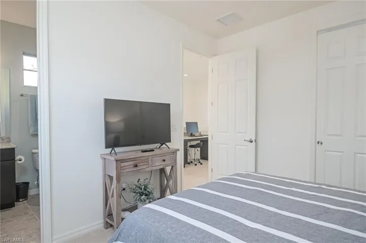 Bedroom featuring tile patterned floors and ensuite bathroom