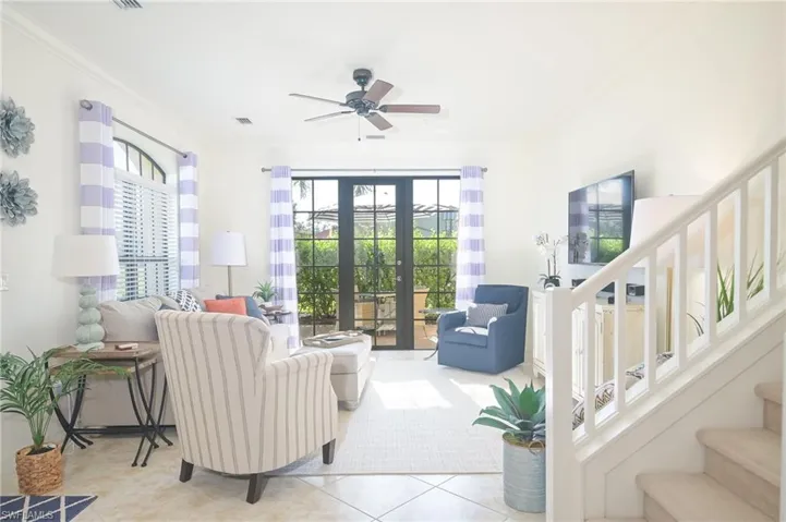 Tiled living room featuring french doors, crown molding, and ceiling fan