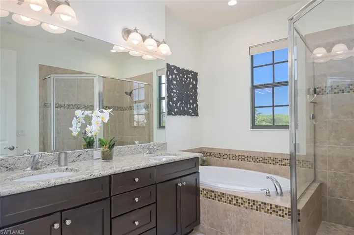 Bathroom with shower with separate bathtub and double sink vanity