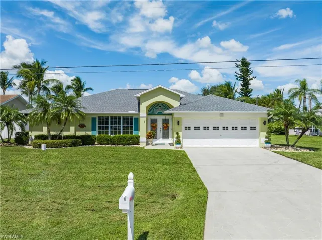 Ranch-style home featuring a front yard and a garage
