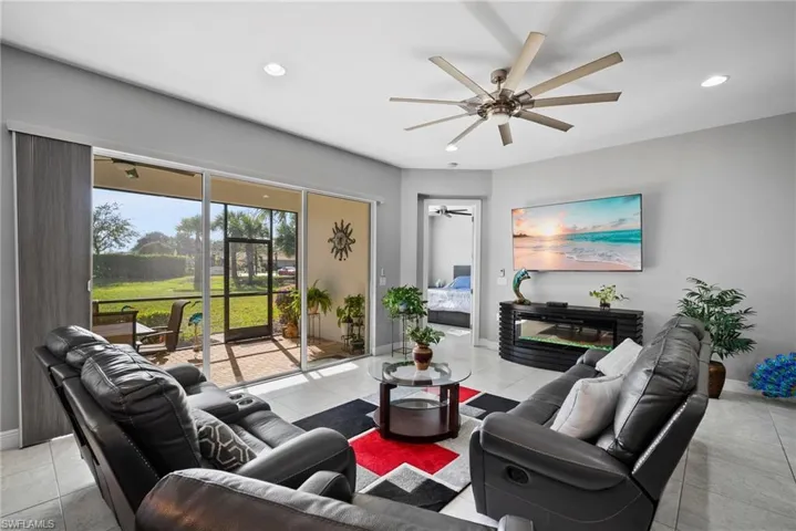 Living room with light tile patterned floors and ceiling fan