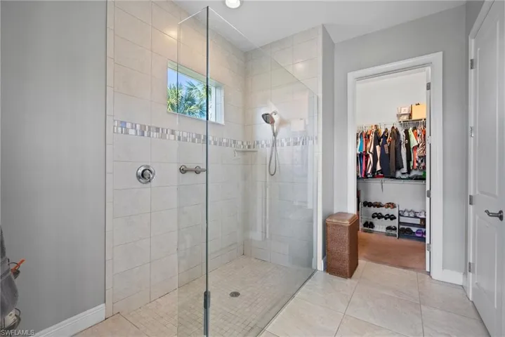Bathroom with tile patterned floors and tiled shower